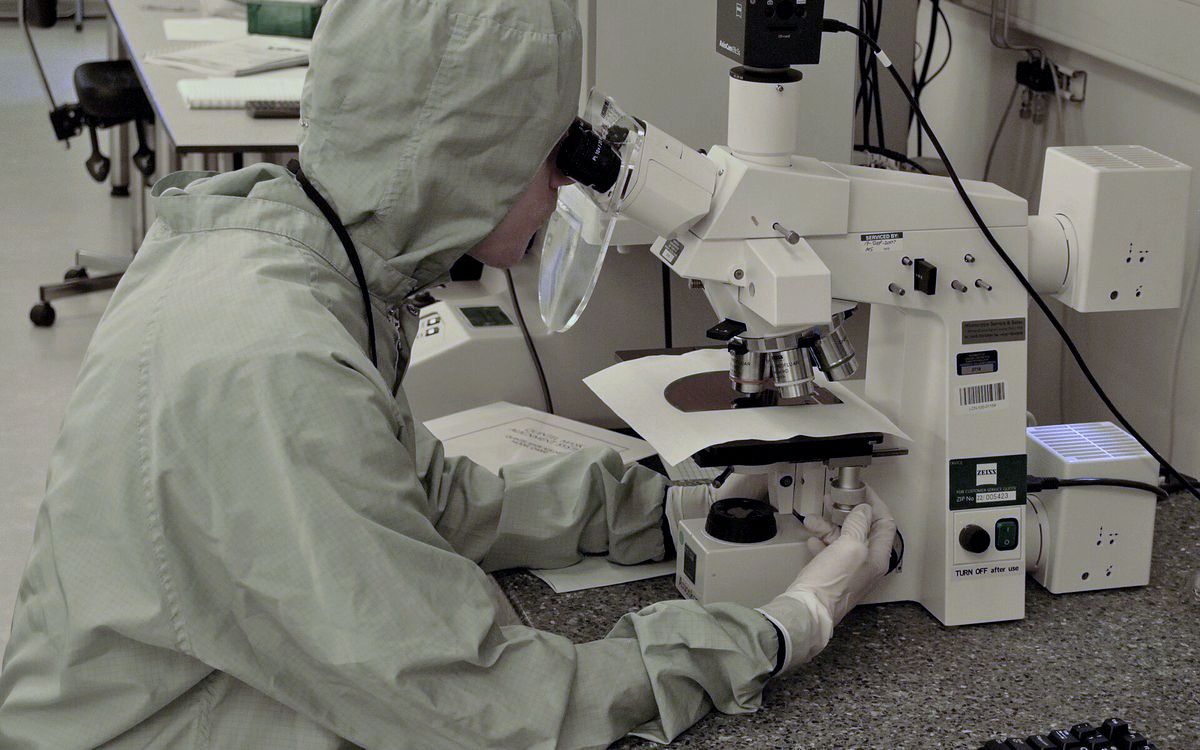 A researcher at a microscope in a laboratory